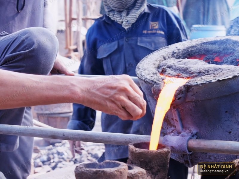 Thợ Đệ Nhất Đỉnh rót đồng nóng chảy vào khuôn tại xưởng Đồng Quỹ, Nam Định